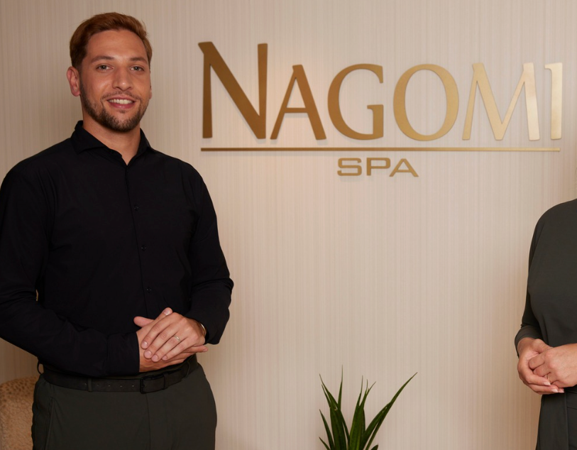 COCON Group's professional spa management and operational leadership team member standing proudly at the Nagomi Spa entrance inside the prestigious Hotel Okura Amsterdam.